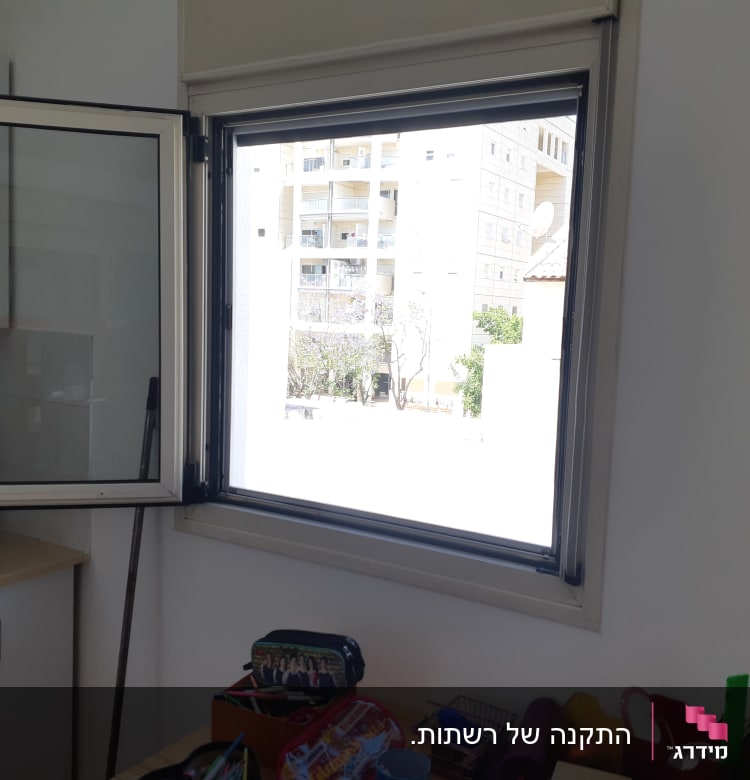 חלון אלומיניום פתוח עם מסגרת אפורה